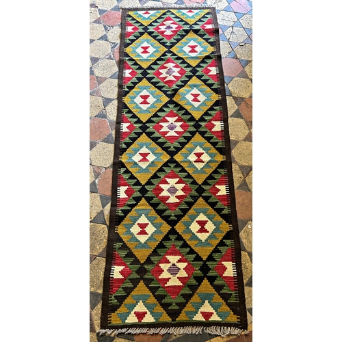 1780 - A Maimana Kilim runner in tones of mustard and green repeating medallions, 203cm x 64cm