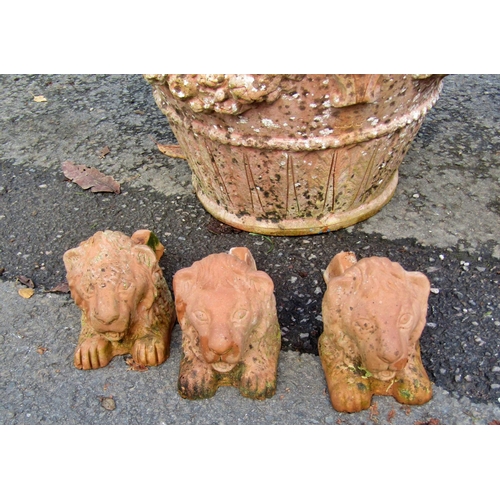 2076 - A weathered terracotta garden planter of circular tapered form with floral swag, lions mask and furt... 