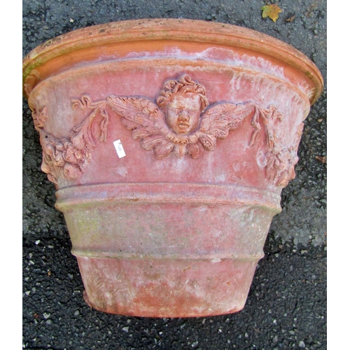 2076 - A weathered terracotta garden planter of circular tapered form with floral swag, lions mask and furt... 