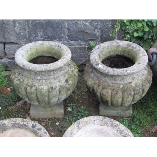 2083 - A pair of nicely weathered cast composition stone garden urns with circular lobbed bodies and square... 