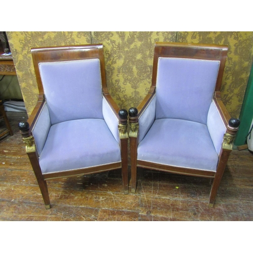 2652 - A pair of Empire style elbow chairs, raised on sabre supports, the show wood frames mounted with ebo... 