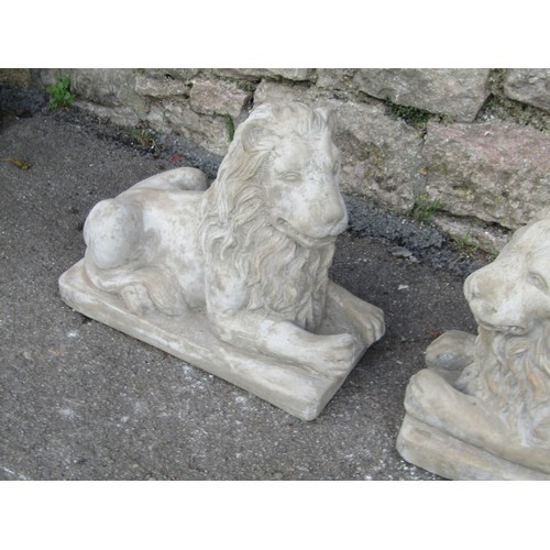 2116 - A symmetrical pair of reconstituted stone garden ornaments in the form of classically presented recu... 