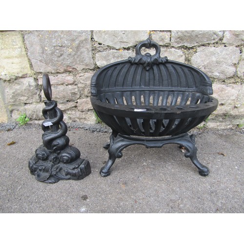 2105 - A small painted cast-iron fire basket, 40 cm high, 38 cm wide together with a cast iron doorstop in ... 