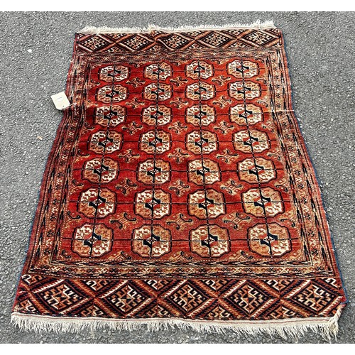 1818 - A Turkoman rug with four rows of elephant foot guls on a faded pink ground, 140 x 106cm approx