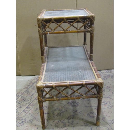 2232 - Three woven wickerwork two-tier occasional tables, each measuring 62 cm high, 66 x 41cm (3)