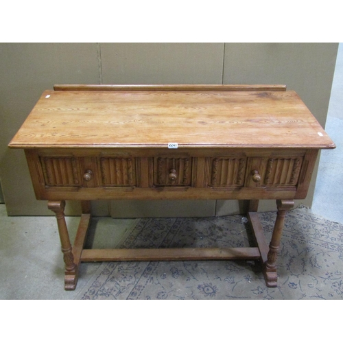 2241 - A small pine side / dressing table, in the Old English / refectory style, fitted with linen fold car... 