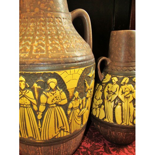 1076 - Two large mid 20th century twin handled West German ceramic vessels, decorated with stylised figural... 