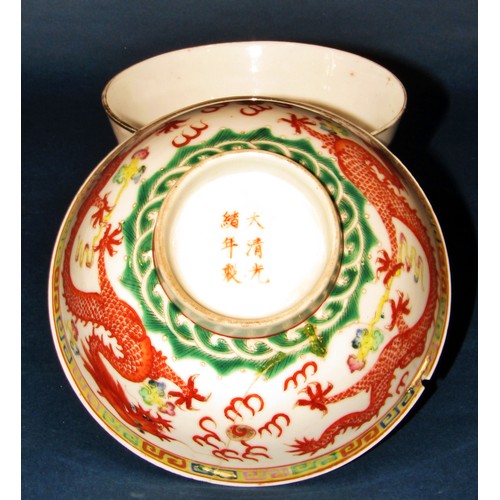 1053A - An early 20th century Chinese porcelain bowl with a dragon and phoenix, 11.5cm wide, together with a... 