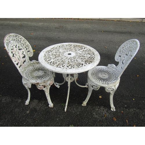 A painted cast aluminium garden terrace table and 2 chairs with decorative pierced details