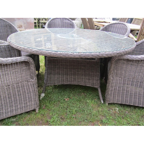 A Oakita Rattan garden suite comprising table the overhanging circular top with plate glass cover 1