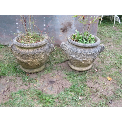 2068A - A pair of weathered cast composition stone circular garden planters in the form of Roman urns with r... 