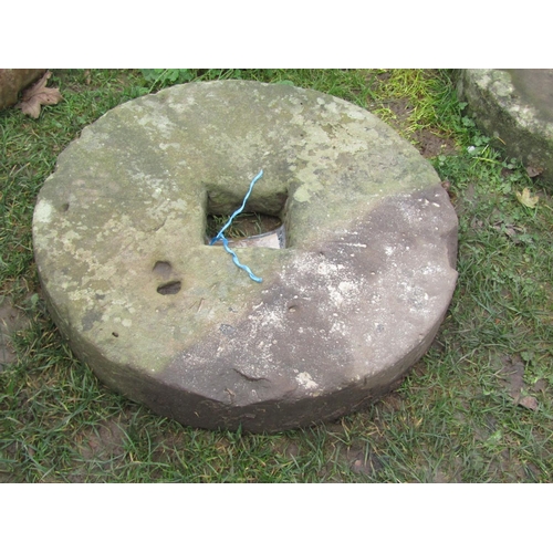 2078 - A weathered millstone with central square cut out, 61 cm diameter x 10 cm thick