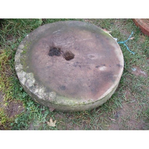 2079 - A weathered stone millstone with small square central cut-out 57 cm diameter x 10 cm thick