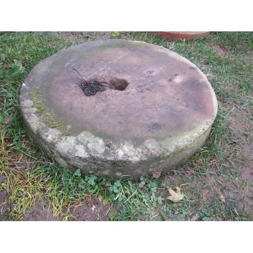 2079 - A weathered stone millstone with small square central cut-out 57 cm diameter x 10 cm thick