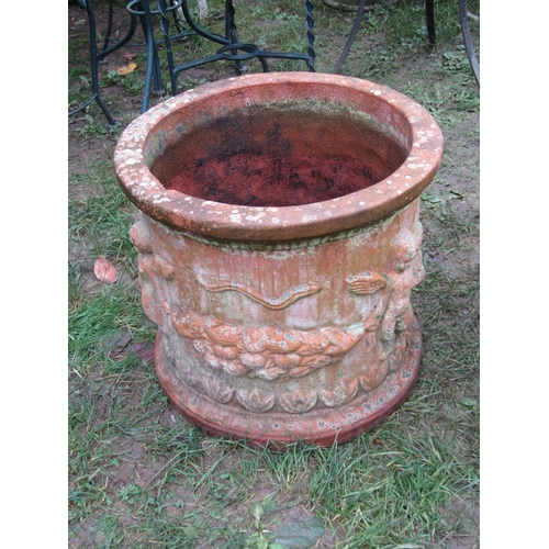 2081 - A weathered squat cylindrical terracotta planter with repeating raised relief winged cherub and frui... 