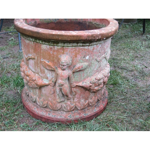 2081 - A weathered squat cylindrical terracotta planter with repeating raised relief winged cherub and frui... 