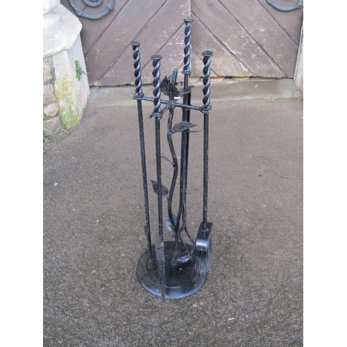 2138A - An unusual iron work fireside companion set with leafed stem support