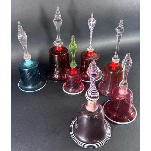 1131A - Seven Victorian Nailsea glass hand bells, 5 in a Cranberry colourway, including two with cotton twis... 