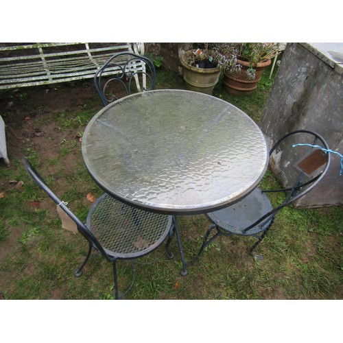 2066 - A weathered cast alloy circular garden terrace table (with loose glass top) together with three simi... 