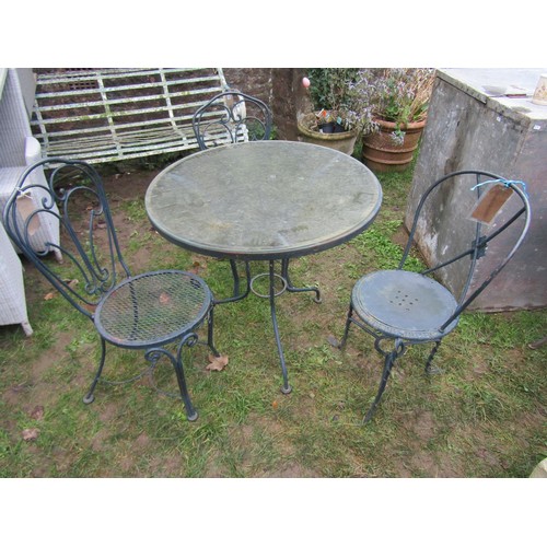 2066 - A weathered cast alloy circular garden terrace table (with loose glass top) together with three simi... 