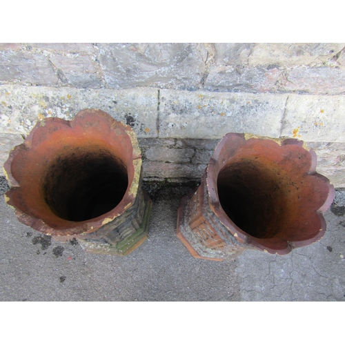 2115 - A pair of 19th century, moulded, terracotta chimney pots with geometric panelled motifs, 74cm high.