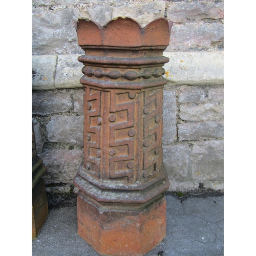 2115 - A pair of 19th century, moulded, terracotta chimney pots with geometric panelled motifs, 74cm high.