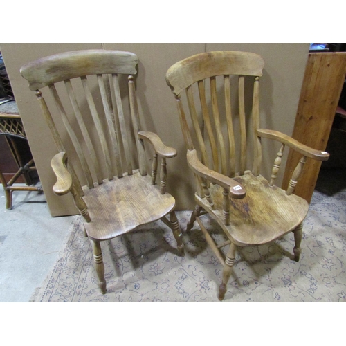 2202 - Two similar antique Windsor elm and beechwood lathe back elbow chairs with saddle shaped seats