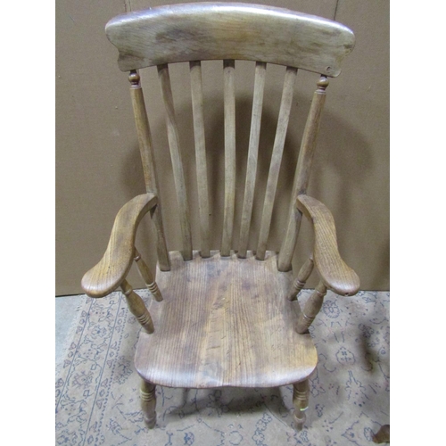 2202 - Two similar antique Windsor elm and beechwood lathe back elbow chairs with saddle shaped seats