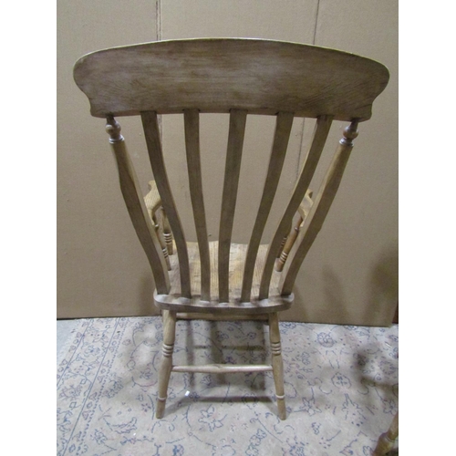 2202 - Two similar antique Windsor elm and beechwood lathe back elbow chairs with saddle shaped seats