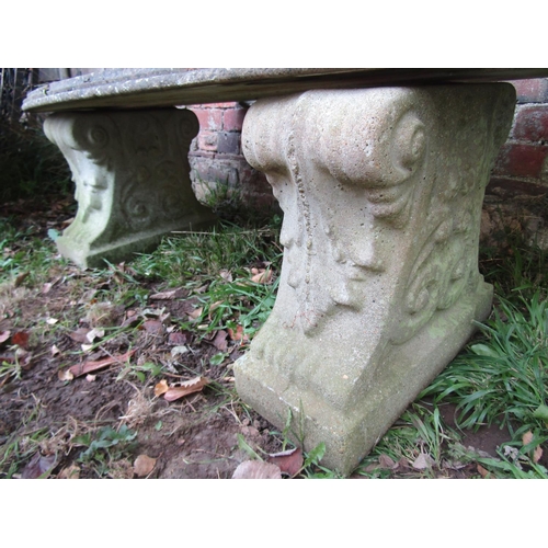 2041 - A weathered composition stone bench of curved form raised on scrolled acanthus supports, 43cm high, ... 