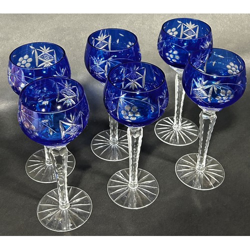 1102 - Six dark blue cut glass hock wine glasses on facetted hexagonal stems. 21cm tall.