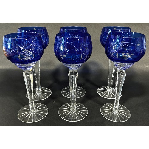 1102 - Six dark blue cut glass hock wine glasses on facetted hexagonal stems. 21cm tall.