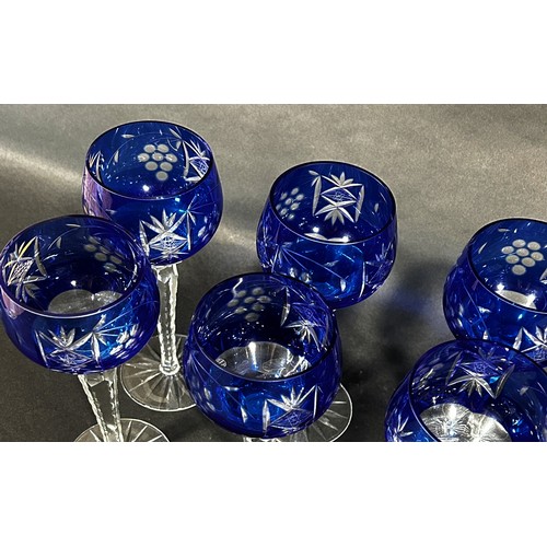 1102 - Six dark blue cut glass hock wine glasses on facetted hexagonal stems. 21cm tall.