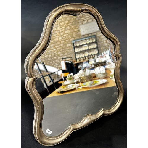 1171 - A silver metal dressing table mirror with a scroll shaped frame, with a wooden back and adjustable s... 