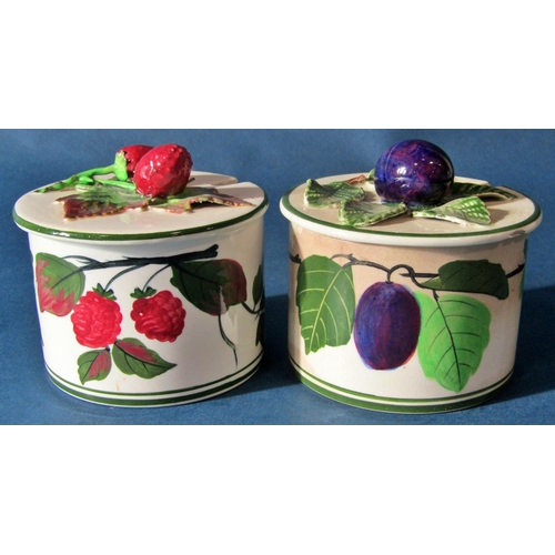 1035 - Two Wemyss type preserve jars and covers with fruit finial lids, together with a Parian ware figure ... 