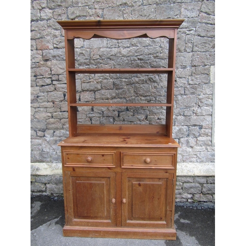 2200 - A small pine kitchen dresser, fitted with two drawers and a pair of panelled doors, below delft rack... 