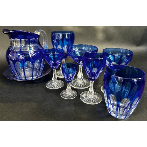 1130 - A miscellaneous collection of glassware, including blue and clear cut glass jug, wine glass champagn... 