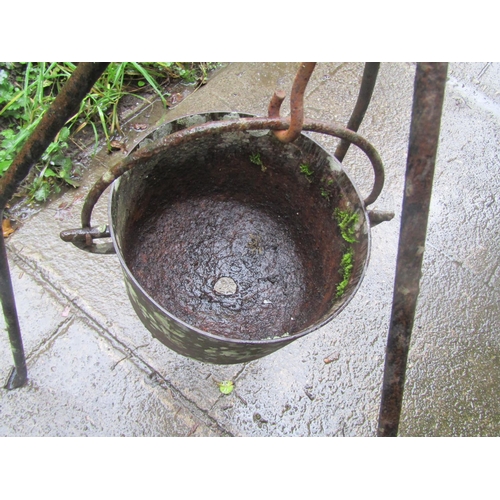 2006 - Antique cast iron cauldron with steel loop handle, hung on an ironwork stand (later used as a garden... 