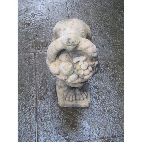 2034 - A weathered cast composition stone garden ornament in the form of a seated hound with basket of frui... 