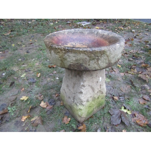 2037 - A weathered composition stone bird bath of circular form raised on a square tapered base, 39cm diame... 