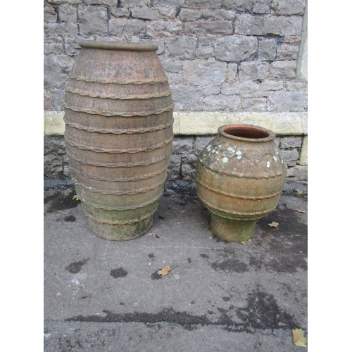 2091 - Two weathered Mediterranean terracotta urns of varying size and design, both with pressed banded det... 