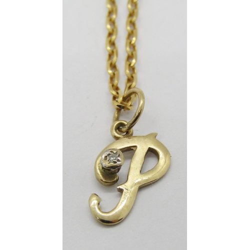 1344 - 9ct three stone dress ring and a 9ct diamond set 'P' pendant / charm hung from a 9ct chain necklace,... 