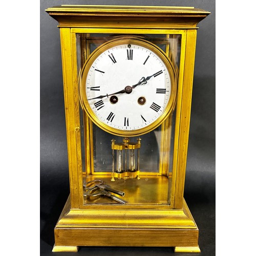 A 19th century four pane brass framed mantle clock with eight day striking movement with mercury compensating pendulum on short supports