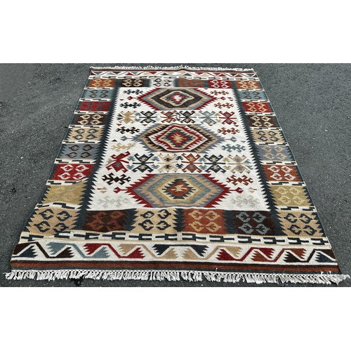 A Kilim Carpet with a central panel of three stepped radiating medallions with a border of square designs, 230cm 175cm approx.