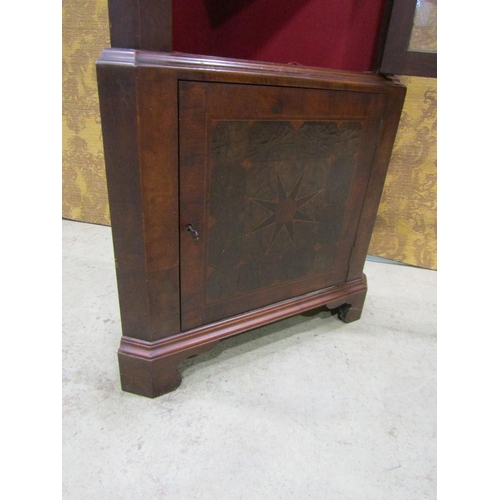 2201 - A Georgian style oyster veneered two sectional free standing corner cabinet, with broken arch pedime... 