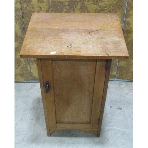 2214 - An Arts & Crafts style oak bedside cupboard, the rectangular over hanging top over a rectangular pan... 