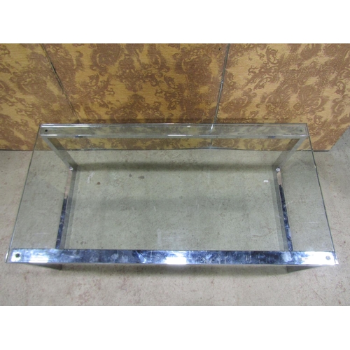 2221 - A modernist low occasional table of rectangular form, raised on chrome supports with tempered glass ... 