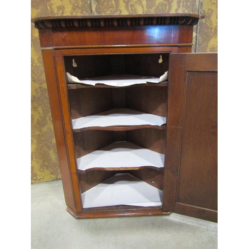 2188 - A Georgian pale oak and mahogany veneered hanging corner cupboard enclosed by a rectangular moulded ... 