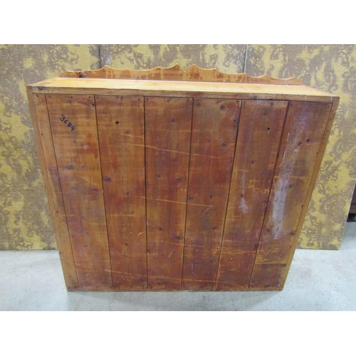 2228 - A stripped pine wall mounted kitchen cabinet enclosed by a pair of glazed and barred panelled doors,... 