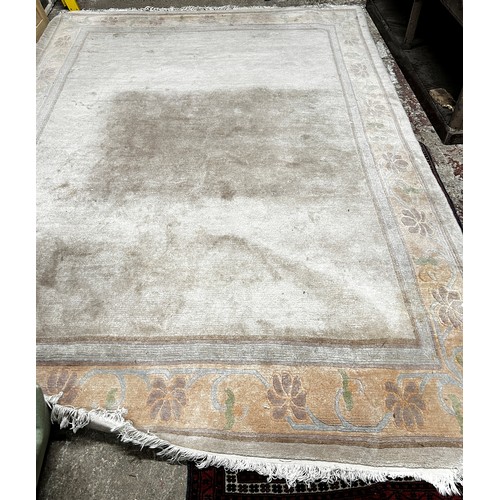 2723 - A large modern Chinese wool carpet in a pale pink with scrolling floral border, (stained in one corn... 